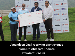 Amandeep Drall receiving giant cheque from Dr. Abraham Thomas-President, JWGC